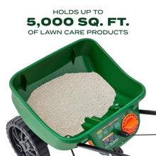 Green spreader hopper filled with granular material and orange control dial