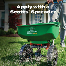 Scotts spreader mini dispensing lawn product onto grass for application