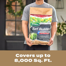 Person holding Scotts Turf Builder weed & feed bag, cover area text on lower panel