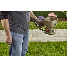 Hand-powered spreader with beige hopper, green base, and orange control lever