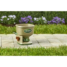 Hand-powered Whirl spreader with beige hopper, green base, and Scotts logo