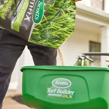 Scotts MAX Southern lawn food bag corner held above green Turf Builder spreader
