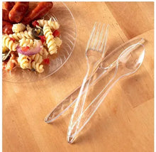 Clear plastic forks and spoons on a flat surface, transparent utensils