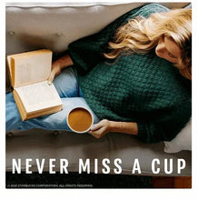 Brewed coffee mug with light amber coffee, held in a hand