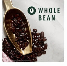 Whole coffee beans with a wooden scoop