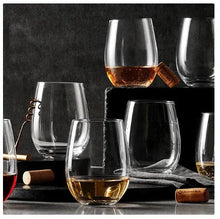 Stemless crystal wine glasses with amber wine, set of multiple clear cups
