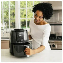 Ninja 4QT black air fryer on countertop with basket handle being pulled
