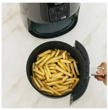 Ninja 4QT black air fryer basket filled with fries, viewed from above