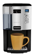 Cuisinart coffee maker pouring into cup, display and control buttons visible