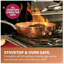Hammered copper skillet on a gas stove with flame and stainless handle