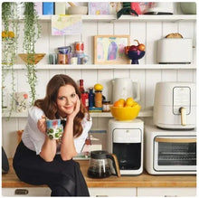 Kitchen counter setup with white portable blender and person holding a drink cup