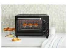 Black toaster oven with glass door showing trays of baked food