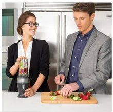 Personal single-serve blender with lid and blending cup in use on countertop