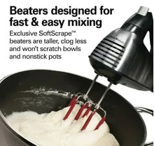 Black and stainless hand mixer with beaters mixing white batter in a bowl