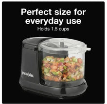 Electric food chopper with clear bowl filled with chopped ingredients