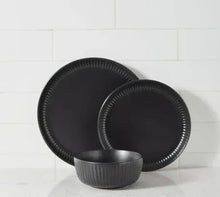 Black stoneware plates with ribbed edges and matching bowl, stack display