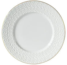 White stoneware dinner plate with raised swirl pattern and gold edge