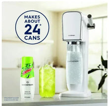 Drink mix canister with green label next to sparkling water bottle