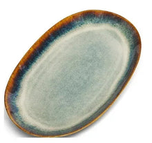 Ceramic oval serving platter with teal interior and warm brown rim, glazed reactive pattern
