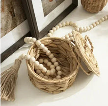 Open natural water hyacinth woven trinket box with lid, spilling beads