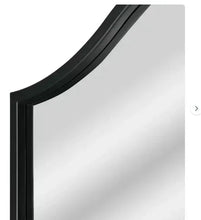Close-up of black arch mirror frame edge and beveled glass reflection