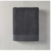 Gray bath towel with textured diamond pattern and folded edge hem.