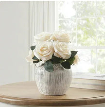 White ribbed stoneware vase with distressed finish holding white roses