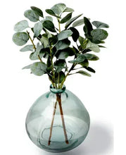 Artificial eucalyptus stems in blown glass vase, teal translucent globe shape
