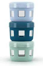 Stacked reusable glass condiment containers with plastic lids in blue, teal, and mint