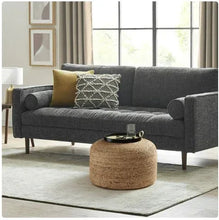 Natural jute cylindrical pouf with woven pattern, styled as a coffee ottoman