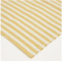 Striped layering rug corner detail with yellow and white diagonal bands