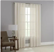 Beige textured curtain panels with rod pocket, hanging with vertical folds by window