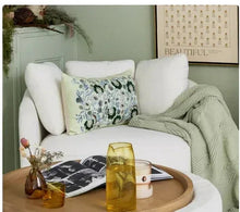 Sage green chenille throw draped over white sofa