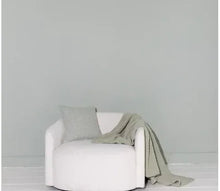Sage green chenille throw casually draped on a chair