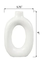 White ceramic donut vase, 5.75 in wide and 6 in tall, circular center opening.
