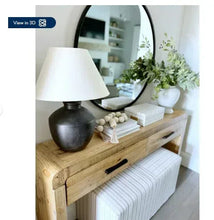 Black urn table lamp with white shade and round textured base