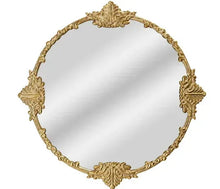 Round ornate gold frame mirror with decorative scrollwork around the edge