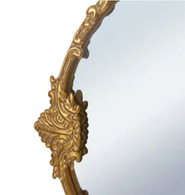 Round mirror frame detail with ornate gold finish and carved scrollwork
