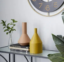 Metal vase set of 2 with matte beige and yellow finishes on a shelf
