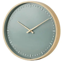 Round green analog wall clock with beige frame, white dot indices, and twin hands