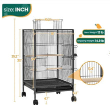 Black wire bird cage with wooden perches and top rack, on caster wheels