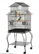 Black metal rolling bird cage with triple roof, perches, and feeding bowls on stand