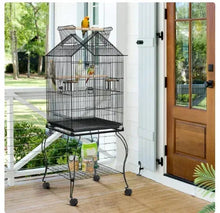 Rolling metal parrot cage with open top, black wire, on wheels on a patio