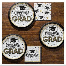 Graduation party plates and napkins on table, black and gold Congrats Grad theme