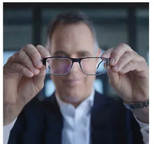 Lens wipes shown with a man holding eyeglasses for lens cleaning