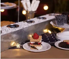 Small white dessert plate topped with berries on a table