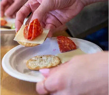 White disposable dessert plate with sliced dessert and hands serving