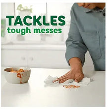 White paper towel used to clean a countertop mess with a hand