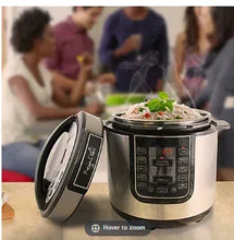 Digital pressure cooker with open lid and stainless steel body, shows control panel display.