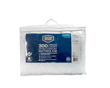 Waterproof queen-size mattress pad in clear plastic packaging with blue label